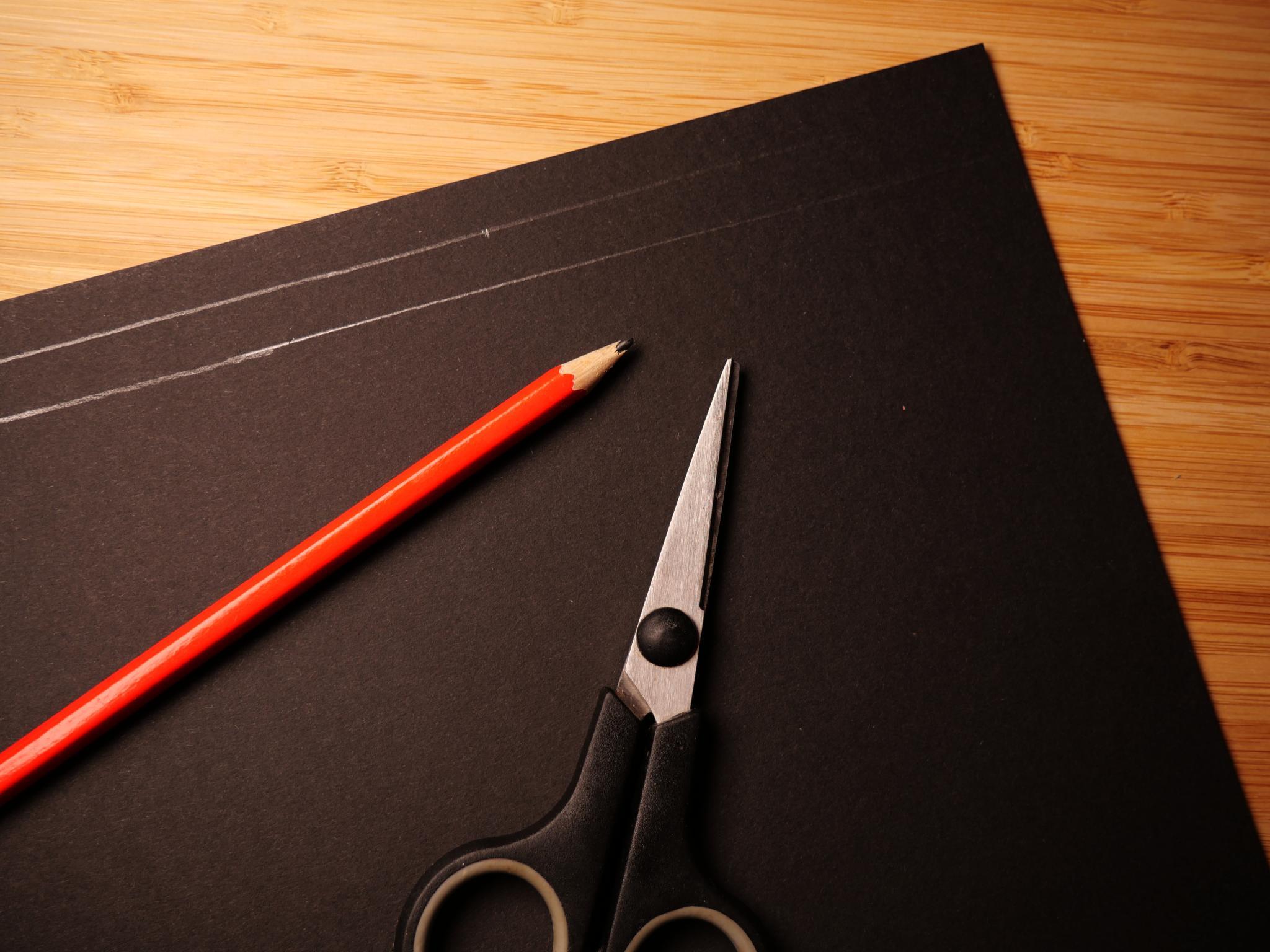 Cutting two 25 x 1 cm stripes out of black cardboard